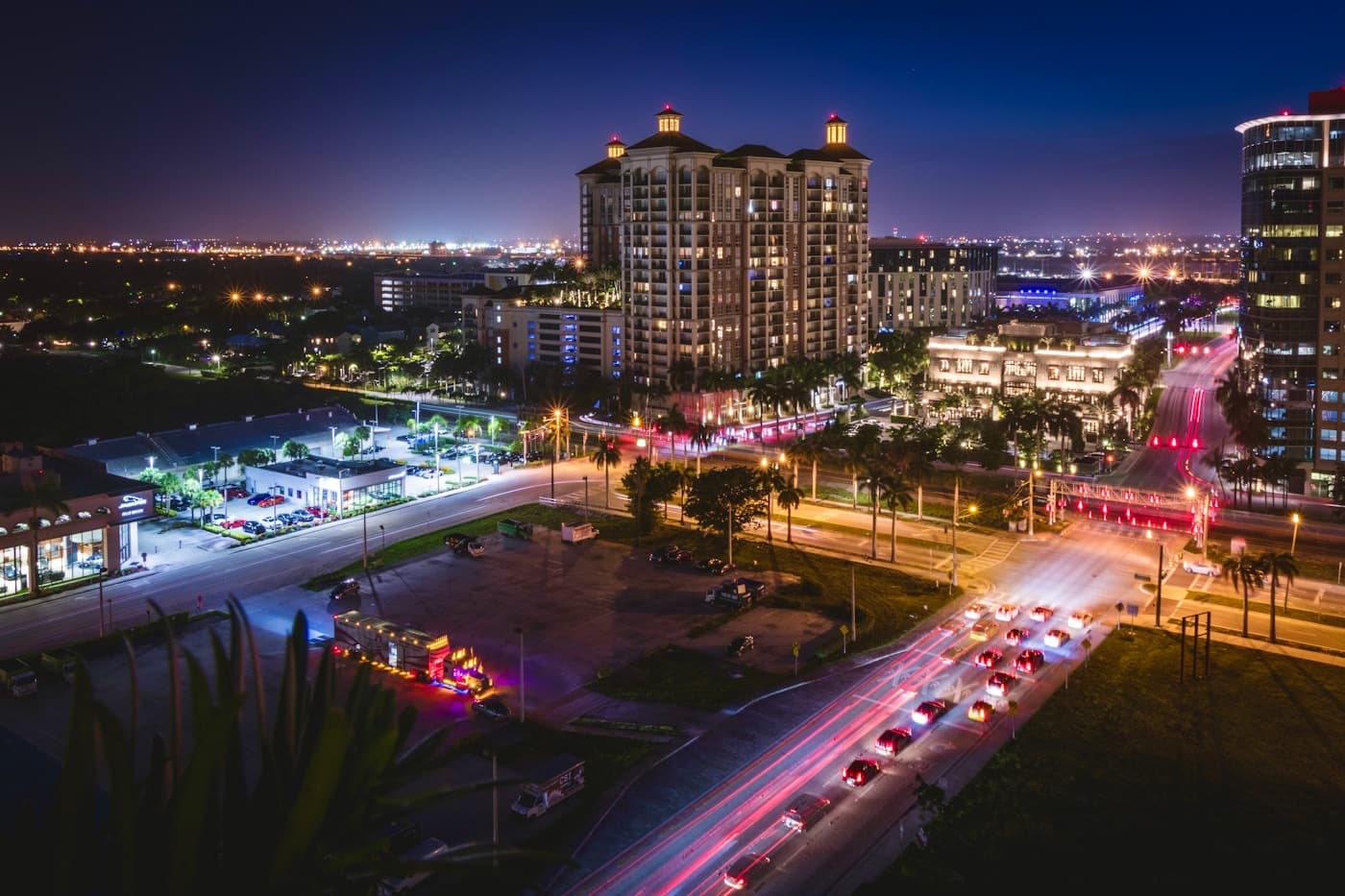 A waterfront city skyline lit up at night beside a bridge.
